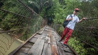 Siswa yang tinggal di daerah tersebut setiap hari terpaksa melintasi jembatan gantung yang rusak tersebut.