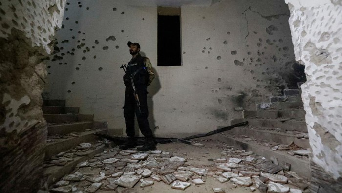 A police officer secures a site as he stands amid the damages in the aftermath of an attack on a police station in Karachi, Pakistan February 17, 2023. REUTERS/Akhtar Soomro     TPX IMAGES OF THE DAY