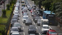 Sejumlah kendaraan terlihat menyalip lewat bahu jalan. 