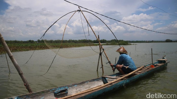 Warga memancing ikan di persawahan yang kebanjiran di Desa Banjarsari, Kecamatan Gabus, Senin (20/2/2023).