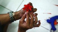 Pekerja sedang menyelesaikan pembuatan kerajinan yang menggunakan bahan baku sampah plastik.