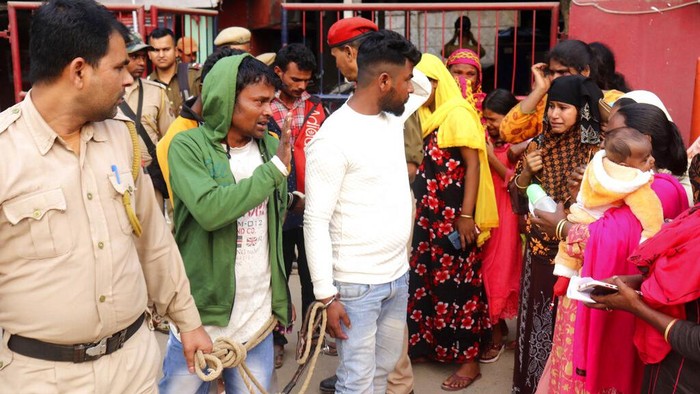 Dilema Kasus Pernikahan Anak India, Sang Pria Ditangkap Istri Merana Siddique Ali, 23, in white shirt, looks at his wife Sonali Begum, second right, 17, after he was picked up by the police, outside a police station in Guwahati, India, Friday, Feb. 3, 2023. Indian police have arrested more than 2,000 men in a crackdown on illegal child marriages in involving girls under the age of 18 a northeastern state. Begum is seven months pregnant. (AP Photo)