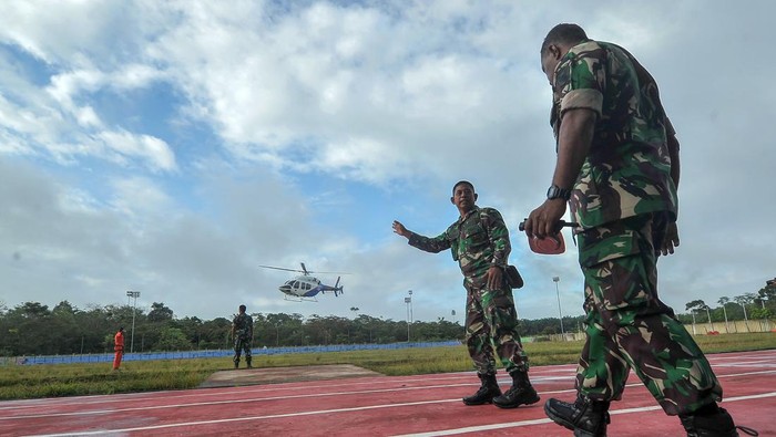 Tim SAR gabungan TNI, Polri, dan Basarnas berjaga saat proses pendaratan Helikopter Bell 429 milik Polri yang digunakan dalam proses evakuasi kecelakaan heli Kapolda Jambi di Stadion Merangin, Jambi, Selasa (21/2/2023). Upaya evakuasi korban oleh Tim Gabungan TNI, Polri dan Basarnas melalui udara yang telah memasuki hari ketiga pada hari ini kembali dilanjutkan setelah sebelumnya menghadapi kendala cuaca buruk. ANTARA FOTO/Wahdi Septiawan/foc.