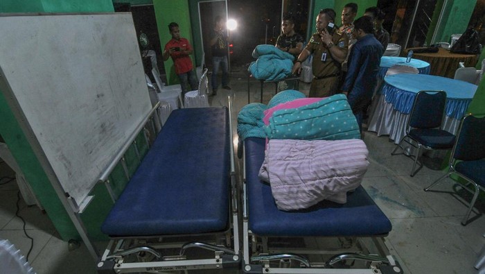 Anggota Kodim 0420/Sarko bersama petugas Dinas Kesehatan Kabupaten Merangin menyiapkan tempat tidur untuk ruang observasi kesehatan darurat korban kecelakaan helikopter di Stadion Merangin, Bangko, Jambi, Senin (20/2/2023). Dinas Kesehatan Kabupaten Merangin, dibantu Kodim 0420/Sarko menyiapkan dua ruangan darurat untuk observasi kesehatan korban kecelakaan helikopter yang ditumpangi Kapolda Jambi di salah satu stadion setempat, sementara evakuasi jalur udara pada hari kedua ini belum berhasil membawa korban akibat cuaca buruk dan akan dilanjutkan besok. ANTARA FOTO/Wahdi Septiawan/tom.