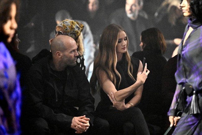 Saat fashion show, Rosie sesekali mengabadikan beberapa look yang diperagakan. Fashion show ini sekaligus menandai koleksi perdana desainer Daniel Lee untuk rumah mode Inggris tersebut. (Foto: Gareth Cattermole/BFC/Getty Images)