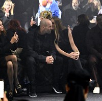 Duduk di front row, sejoli yang tampil kompak dalam balutan busana serba hitam ini sesekali menunjukkan kemesraan. (Foto: Gareth Cattermole/BFC/Getty Images)