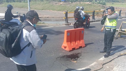 Kondisi jalan yang jebol di ujung barat jembatan Bilukpoh, Kelurahan Tegalcangkring, Kecamatan Mendoyo, Kabupaten Jembrana, Selasa (21/2/2023).