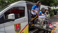 Seorang perawat membantu seorang anak berkebutuhan khusus turun dari mobil ambulans setelah mencoba fasilitas ambulans khusus disabilitas di Kantor Kecamatan Semarang Barat, Kota Semarang, Jawa Tengah, Selasa (21/2/2023).