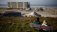 Orang-orang melihat penghancuran gedung Signa di Soulac-sur-Mer, Prancis, 9 Februari 2023. Penghuni apartemen ini telah dievakuasi pada tahun 2014 lalu. Ketika dibangun pada akhir tahun enam puluhan di salah satu garis pantai Atlantik paling megah di Prancis, pantai itu berjarak lebih dari 200 meter.  