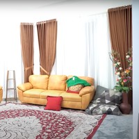 Masuk ke bagian dalam rumah terlihat ruang tamu yang cukup luas. Didominasi warna coklat, ruang tamu di rumah Haji Faisal tampak nyaman dengan dilengkapi sofa dan juga karpet. Foto: YouTube/Fuji an