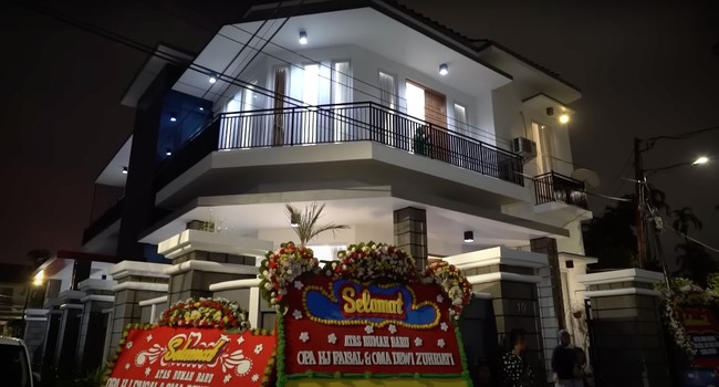 Melalui akun YouTube pribadinya Fuji tampak memamerkan rumah baru milik kedua orangtuanya. Dari luar rumah tersebut tampak begitu megah dengan didominasi warna putih dan abu-abu. Foto: YouTube/Fuji an