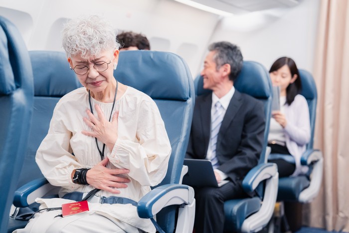 Elderly Woman Suffering from Illness on Airplane