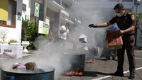 Petugas memusnahkan narkotika dengan cara dibakar di halaman kantor Kejaksaan Negeri Denpasar, Bali.