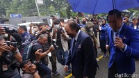 AHY menyambut dan memayungi Surya Paloh saat berjalan masuk ke kantor DPP Partai Demokrat.