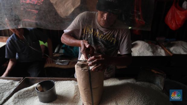 Pekerja mengangkat karungan beras di Pasar Tradisional Kebayoran Lama, Rabu, (22/2). (CNBC Indonesia/ Muhammad Sabki)