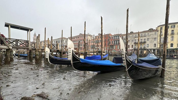 Penampakan Langka Kanal Venesia Surut, Peringatan Baru Kekeringan Italia Passengers get off a gondola docked along a canal during a low tide in Venice, Italy, Tuesday, Feb. 21, 2023. Some ofΒ Venice's secondary canals have practically dried up lately due a prolonged spell of low tides linked to a lingering high-pressure weather system. (AP Photo/Luigi Costantini)
