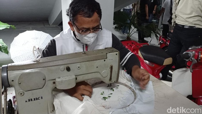 Perajin kain bordir manual tengah tekun bekerja.