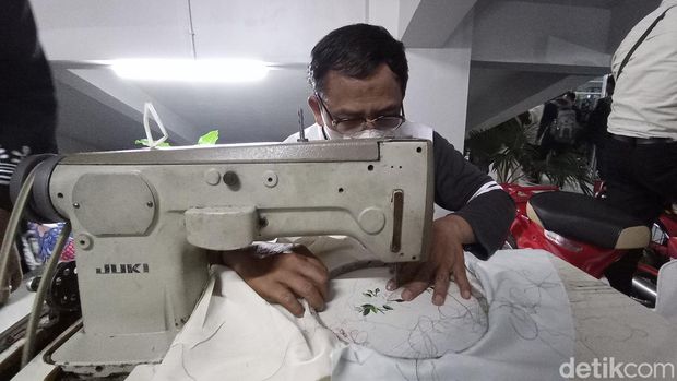 Perajin kain bordir manual tengah tekun bekerja.