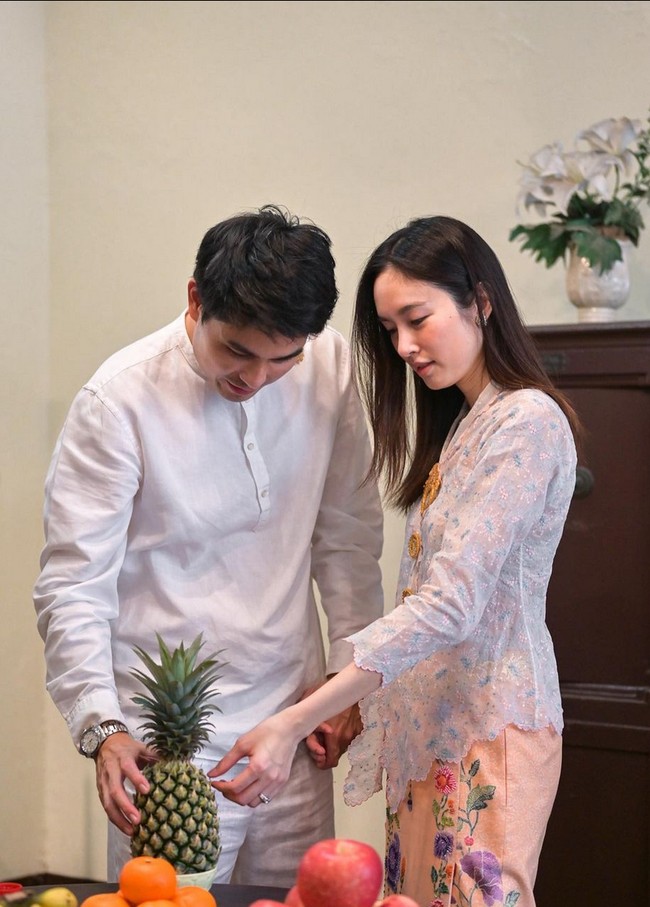 Sang tunangan, Oak Phakwa Hongyko tampil bersahaja dengan busana putih-putih. Pria yang disebut sebagai crazy rich ini mengenakan baju kerah tinggi dengan celana putih. Foto: Dok. Instagram/@poydtreechada