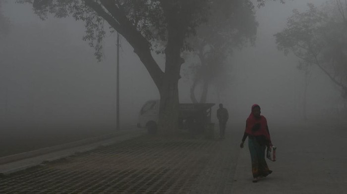 Gelapnya New Delhi Diselimuti Polusi Udara TOPSHOT - People walk along a road near India Gate amid heavy smog in New Delhi on February 22, 2023. (Photo by Arun SANKAR / AFP) (Photo by ARUN SANKAR/AFP via Getty Images)