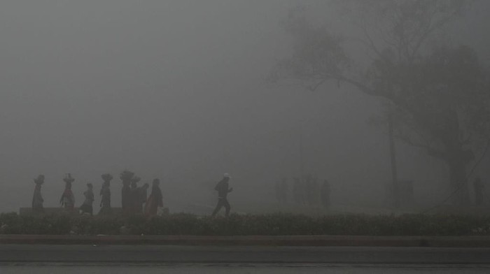Gelapnya New Delhi Diselimuti Polusi Udara TOPSHOT - People walk along a road near India Gate amid heavy smog in New Delhi on February 22, 2023. (Photo by Arun SANKAR / AFP) (Photo by ARUN SANKAR/AFP via Getty Images)
