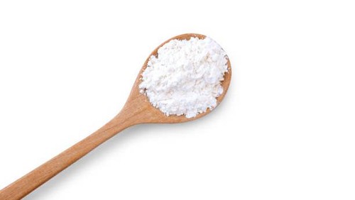 Calcium hydroxide powder (Deydrated lime) in wooden spoon isolated on white background. Top view. Flat lay.