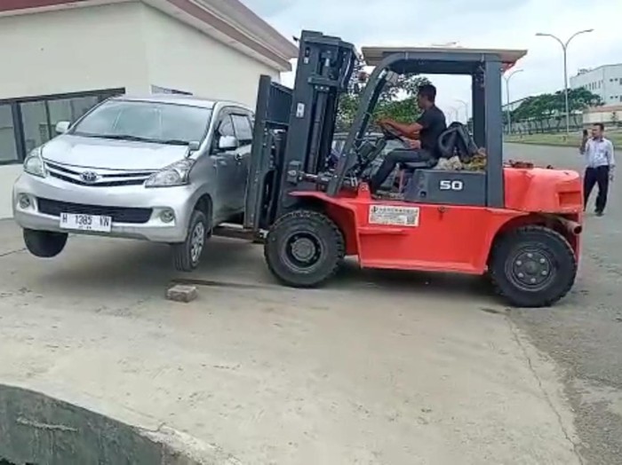 Mobil yang memblokade akses PT Golden Tekstil di Kendal dipindahkan ke halaman pabrik menggunakan forklift, Rabu (22/2/2023).