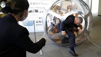Keisuke Iwaya, CEO of a Japanese space development company, Iwaya Giken, unveils a two-seater cabin and a balloon that the company says is capable of rising to an altitude of 15 miles, which is roughly the middle of the stratosphere, as he speaks during a news conference in Tokyo, Tuesday, Feb. 21, 2023. The Japanese startup company announced plans Tuesday to launch a commercial space viewing balloon flight that it hopes will bring down to earth an otherwise astronomically expensive experience. (AP Photo/Eugene Hoshiko)