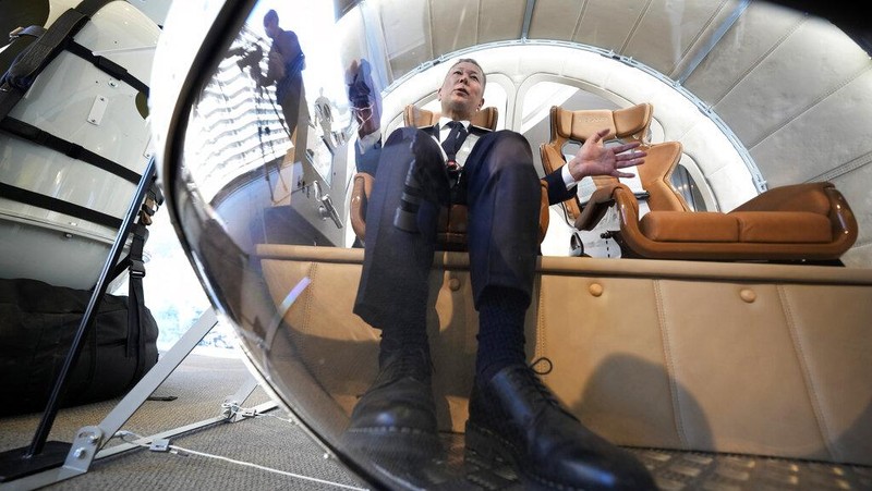 Keisuke Iwaya, CEO of a Japanese space development company, Iwaya Giken, unveils a two-seater cabin and a balloon that the company says is capable of rising to an altitude of 15 miles, which is roughly the middle of the stratosphere, as he speaks during a news conference in Tokyo, Tuesday, Feb. 21, 2023. The Japanese startup company announced plans Tuesday to launch a commercial space viewing balloon flight that it hopes will bring down to earth an otherwise astronomically expensive experience. (AP Photo/Eugene Hoshiko)