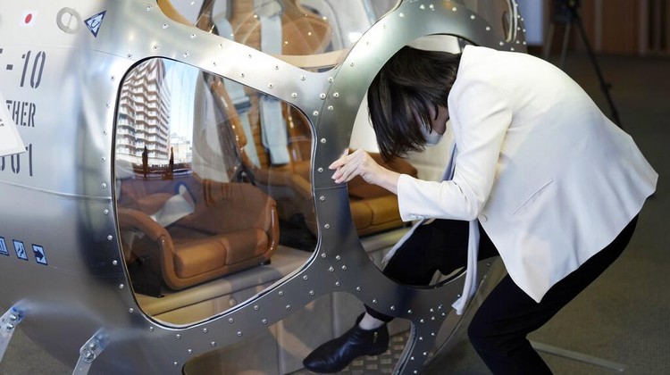 Keisuke Iwaya, CEO of a Japanese space development company, Iwaya Giken, unveils a two-seater cabin and a balloon that the company says is capable of rising to an altitude of 15 miles, which is roughly the middle of the stratosphere, as he speaks during a news conference in Tokyo, Tuesday, Feb. 21, 2023. The Japanese startup company announced plans Tuesday to launch a commercial space viewing balloon flight that it hopes will bring down to earth an otherwise astronomically expensive experience. (AP Photo/Eugene Hoshiko)