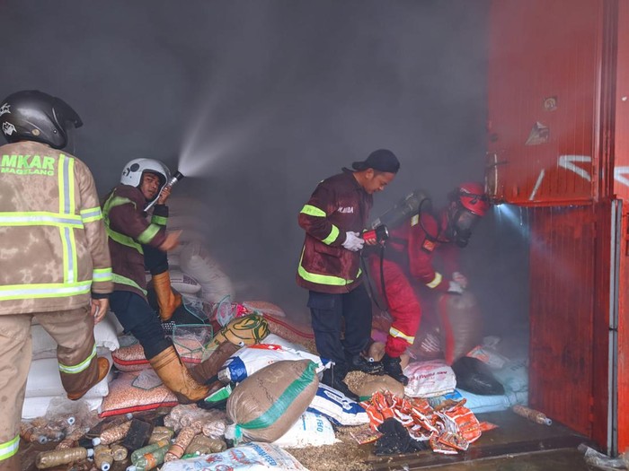 Petugas Pemadam Kebakaran Kabupaten Magelang memadamkan kobaran api di toko pakan ternak yang terbakar, Kamis (23/2/2023).