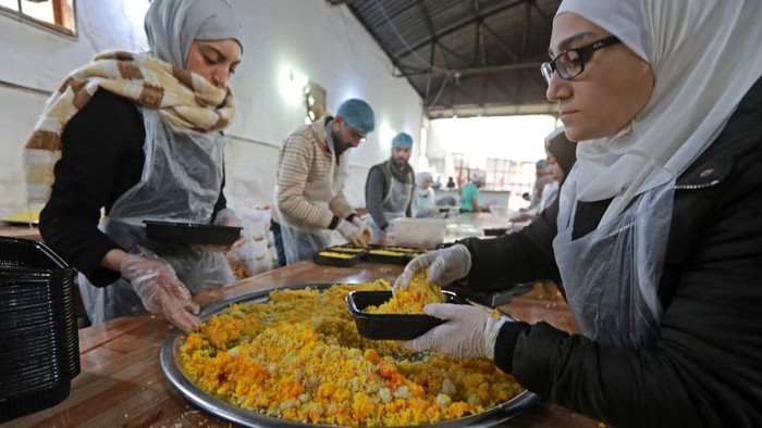 Potret Kesibukan Dapur Umum Korban Gempa Suriah Volunteers prepare food to serve people affected by the 7.8-magnitude quake, in the government-held northern city of Aleppo on February 21, 2023 . - Aleppo, once a major commercial hub, had already been battered by over a decade of war when the 7.8-magnitude quake struck in early February, killing more than 45,000 people across Turkey and Syria and flattening entire neighbourhoods. (Photo by LOUAI BESHARA / AFP) (Photo by LOUAI BESHARA/AFP via Getty Images)