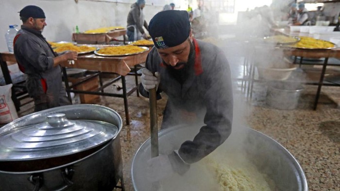 Potret Kesibukan Dapur Umum Korban Gempa Suriah Volunteers prepare food to serve people affected by the 7.8-magnitude quake, in the government-held northern city of Aleppo on February 21, 2023 . - Aleppo, once a major commercial hub, had already been battered by over a decade of war when the 7.8-magnitude quake struck in early February, killing more than 45,000 people across Turkey and Syria and flattening entire neighbourhoods. (Photo by LOUAI BESHARA / AFP) (Photo by LOUAI BESHARA/AFP via Getty Images)