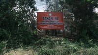 Plang spanduk bergambar merah menyulut Tanah Ini Dalam Pengawasan Pemerintah Kota Pontianak Karena Melanggar Perwa Nomor 114 Tahun 2021 Tentang Kebakaran Hutan dan Lahan berdiri di atas lahan yang masih terlihat sisa-sisa kebakaran.  