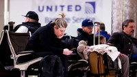 Sejumlah penumpang duduk di Bandara Internasional Denver setelah penerbangannya dibatalkan karena badai musim dingin di Denver, Colorado, Rabu (22/2/2023).