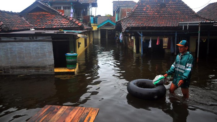 Banjir Kembali Terjang Kudus, Warga Diimbau Mengungsi Warga melintasi jalan yang tergenang banjir di Dukuh Tanggulangin, Jati Wetan, Kudus, Jawa Tengah, Jumat (24/2/2023). Banjir yang menerjang wilayah setempat sejak empat hari yang lalu itu menggenangi 300 rumah dengan ketinggian hingga 90 centimeter serta sebanyak 700 Kepala Keluarga terdampak dan warga dihimbau untuk mengungsi menyusul curah hujan masih tinggi.