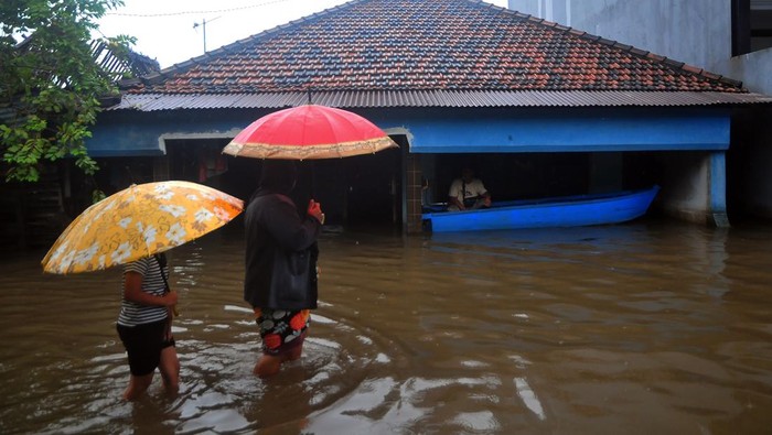 Banjir Kembali Terjang Kudus, Warga Diimbau Mengungsi Warga melintasi jalan yang tergenang banjir di Dukuh Tanggulangin, Jati Wetan, Kudus, Jawa Tengah, Jumat (24/2/2023). Banjir yang menerjang wilayah setempat sejak empat hari yang lalu itu menggenangi 300 rumah dengan ketinggian hingga 90 centimeter serta sebanyak 700 Kepala Keluarga terdampak dan warga dihimbau untuk mengungsi menyusul curah hujan masih tinggi.