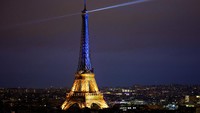 Menara Eiffel diterangi dengan warna biru-kuning nasional Ukraina, untuk menandai peringatan pertama invasi Rusia ke Ukraina, di Paris, Prancis. REUTERS/Sarah Meyssonnier