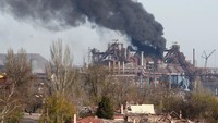 Asap mengepul di atas pabrik Pekerjaan Besi dan Baja Azovstal selama konflik Ukraina-Rusia di kota pelabuhan selatan Mariupol. Sudah tidak terhitung berapa jumlah korban yang tewas dan berapa banyak kehancuran yang tercipta akibat invasi yang disebut Putin operasi militer besar-besaran itu. REUTERS/Alexander Ermochenko