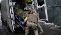 Petugas medis menempatkan seorang tentara Ukraina yang terluka dalam kendaraan darurat untuk membawanya ke rumah sakit, di luar titik stabilisasi medis garis depan, di tengah serangan Rusia di Ukraina, dekat Vuhledar. REUTERS/Marko Djurica  