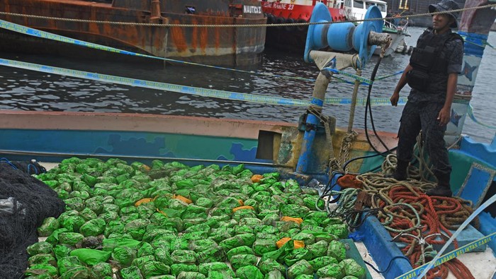 BNN Amankan Ratusan Narkotika Jenis Sabu di Pelabuhan Merak Aparat Bea Cukai bersama BNN (Badan Narkotika Nasional) menjaga para tersangka penyelundup narkotika bersama barang bukti ratusan paket narkotika jeni sabu di Pelabuhan Indah Kiat, Merak, Banten, Jumat (24/2/2023). Petugas patroli Bea Cukai Merak hari Kamis (23/2) menahan kapal nelayan di Selatan Pulau Jawa yang ditumpangi 8 warga negara Iran dan setelah digeledah ditemukan 309 paket narkotika jenis sabu yang disembunyikan di bawah mesin kapal. ANTARA FOTO/Asep Fathulrahman/foc.