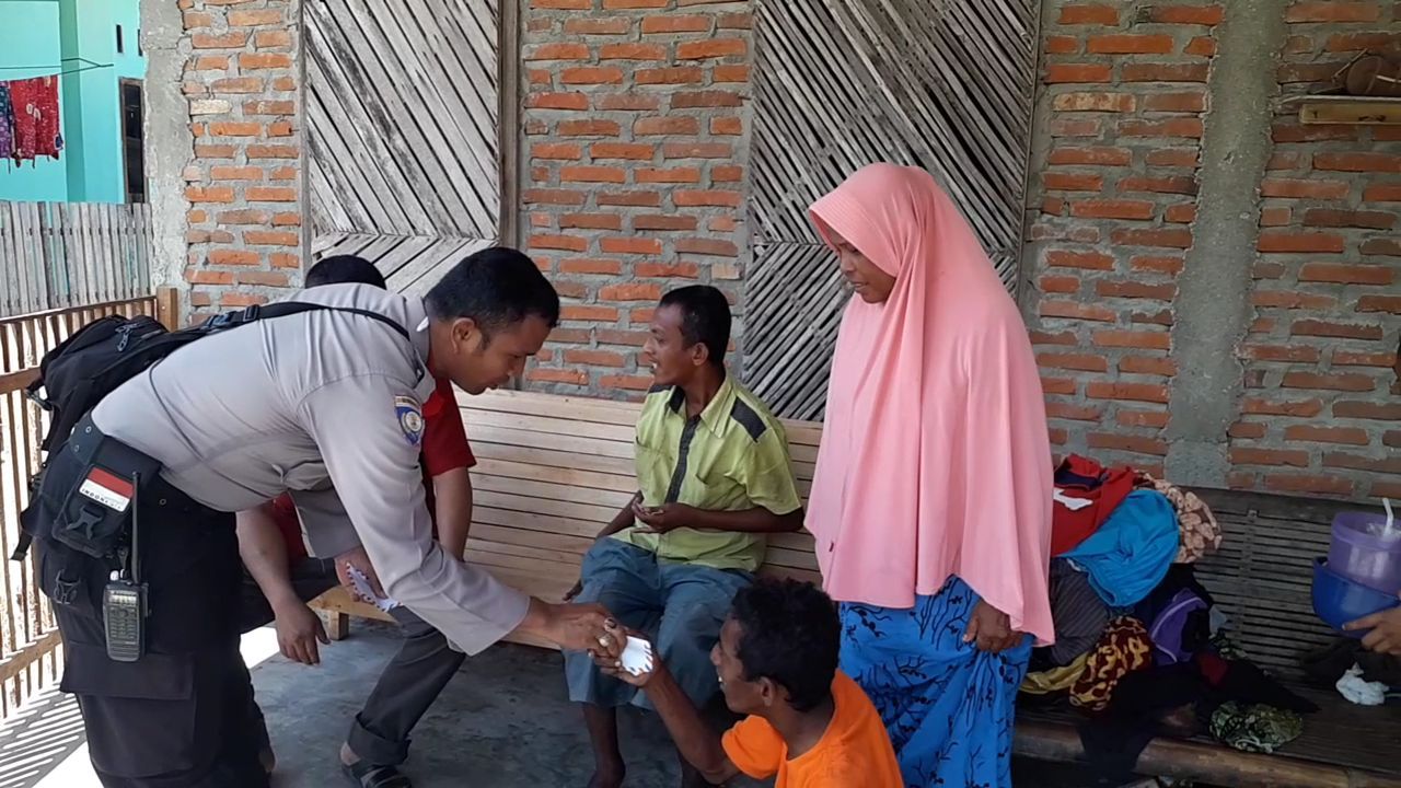 Bripka Ibrahim memberikan bantuan kepada warga