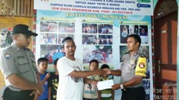 Bripka Ibrahim menyerahkan bantuan secara simblis keLhok Kaju English Center.