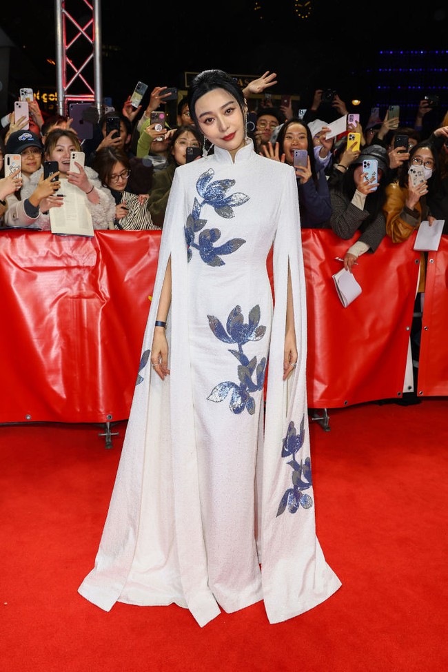 Saat premier Green Night di Festival Film Berlin 2023, Fan Bingbing melenggang di karpet merah dengan gaun putih panjang berkerah cheongsam dari desainer China, Christopher Bu. Gaun tersebut hadir dengan detail bunga berwarna biru yang berkilauan. Foto: Getty Images