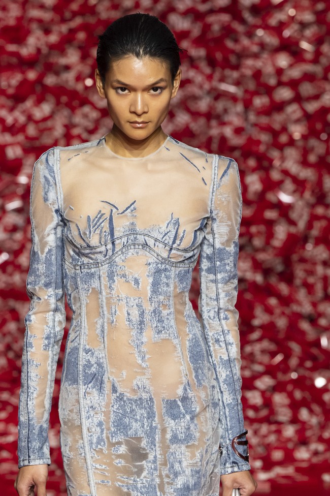 Glenn menggunakan devoré denim, yakni material denim yang diolah dengan teknik pembuatan kain beludu atau velvet. Dalam proses tersebut, kain dibuat memudar menjadi semacam polyester organza sehingga menghasilkan tekstur yang transparan. (Foto: Victor VIRGILE/Gamma-Rapho via Getty Images)