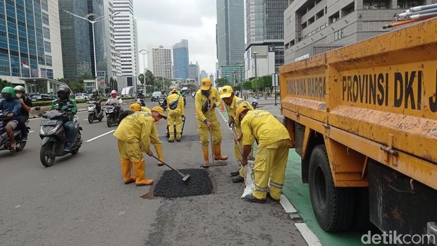 Petugas Bina Marga melakukan penambalan jalan berlubang di Jalan MH Thamrin, Jakarta, Jumat (24/2/2023).