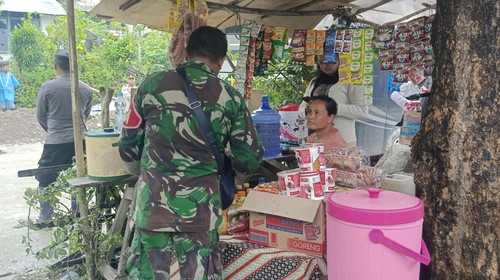 Ocy Tuka Doji melayani pembeli di warungnya yang dibuka di lokasi longsor Kelurahan Takari, Kabupaten Kupang, NTT, Kamis (23/2/2023).