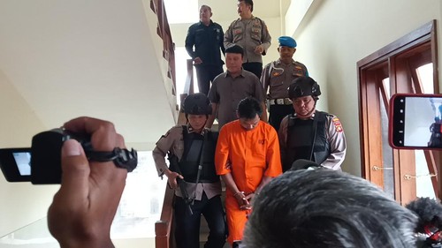 Pemilik Uncle Benz Cafe I Gede Wijaya digiring polisi saat konferensi pers terkait kasus tewasnya bule Australia bernama Johnston Mccallum Scott di Mapolsek Kuta Selatan, Jumat (24/2/2023). (Triwidyanti/detikBali)