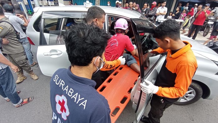 Petugas mengevakuasi korban yang masih di kemudi mobil