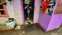 Warga membersihkan rumahnya yang sempat terendam banjir.
